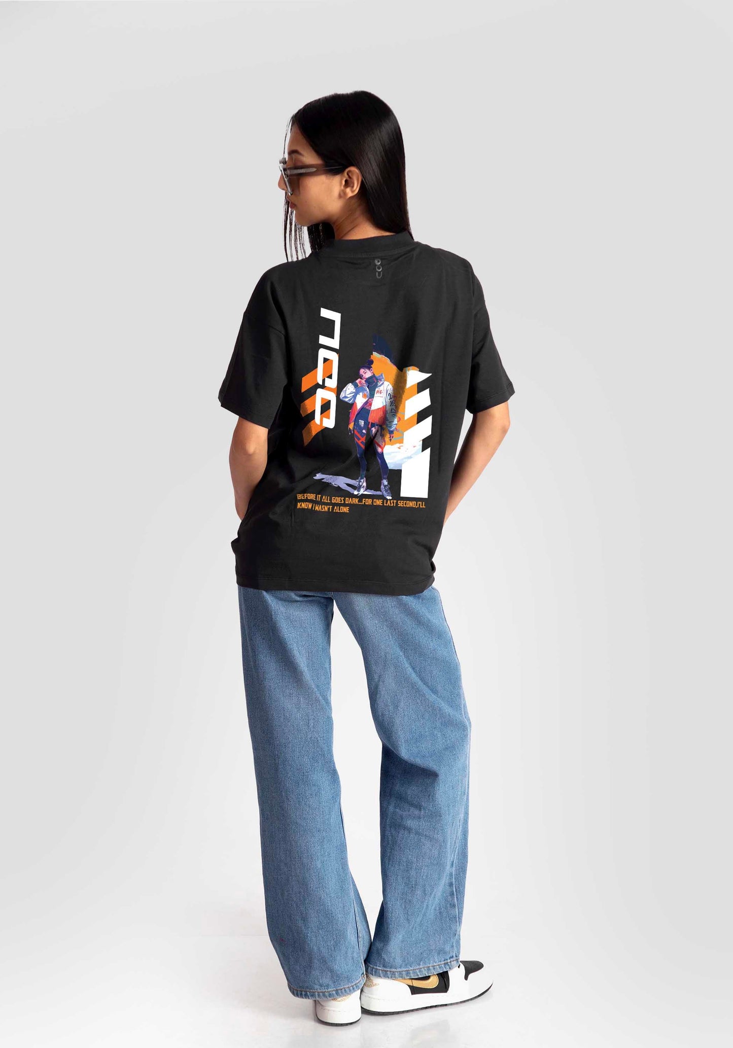 Black streetwear oversized tee womens by Stylera with graphic print on back paired with blue jeans