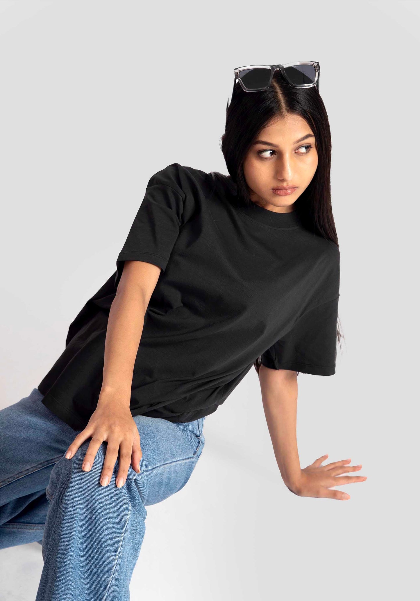 Stylera black streetwear oversized tee womens styled with blue jeans and sunglasses