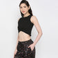 Model wearing a black twisted crop top paired with stylish patterned pants for a trendy look