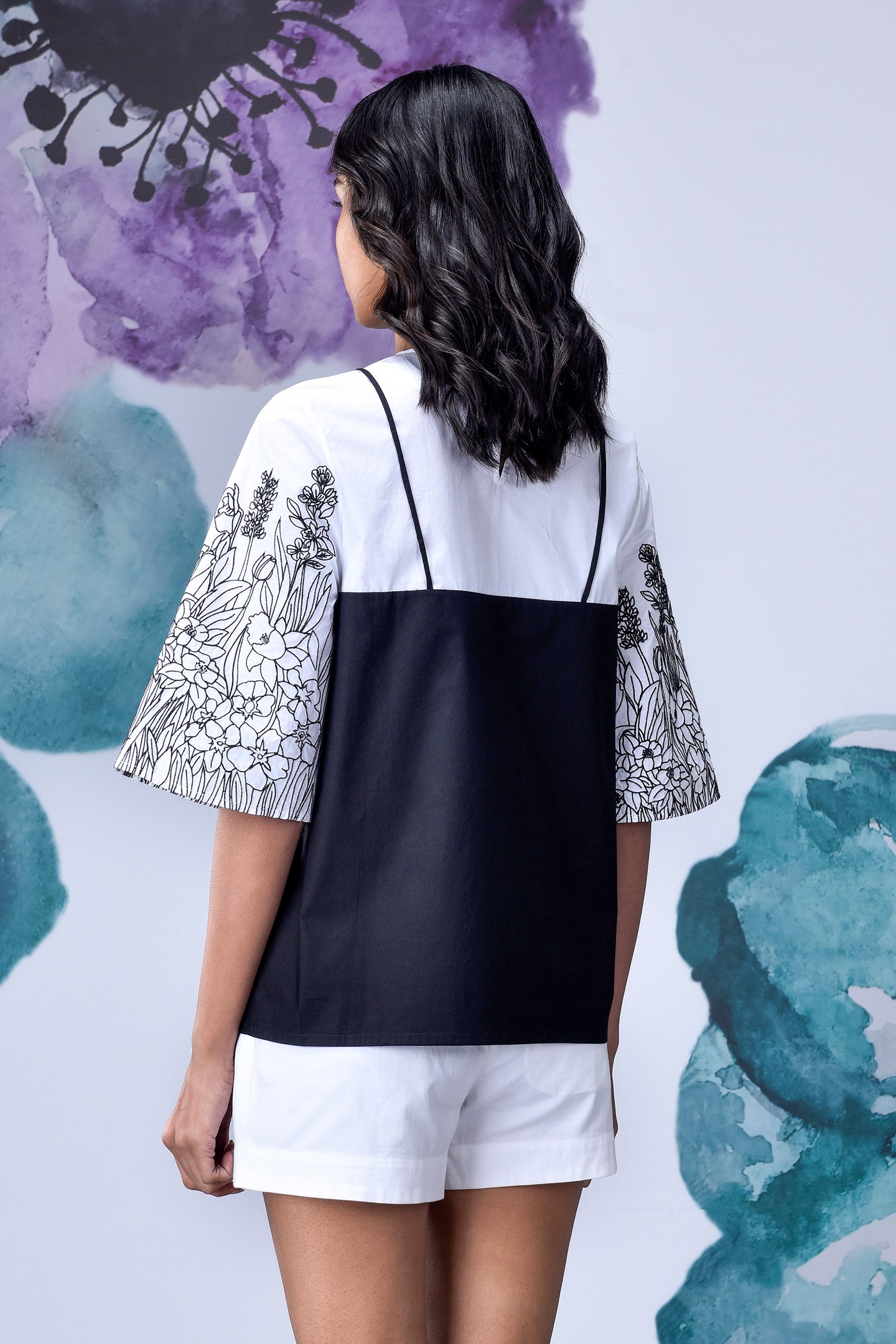 Back view of Stylera black white layered top with floral printed wide sleeves and contrast panel