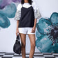 Model wearing Stylera black white layered top over patterned white tee with white shorts