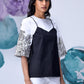 Model wearing Stylera black white layered top with floral elbow sleeves and white shorts