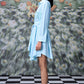 Stylera model in blue green stripe dress shirt style belted mini dress side profile with floral backdrop
