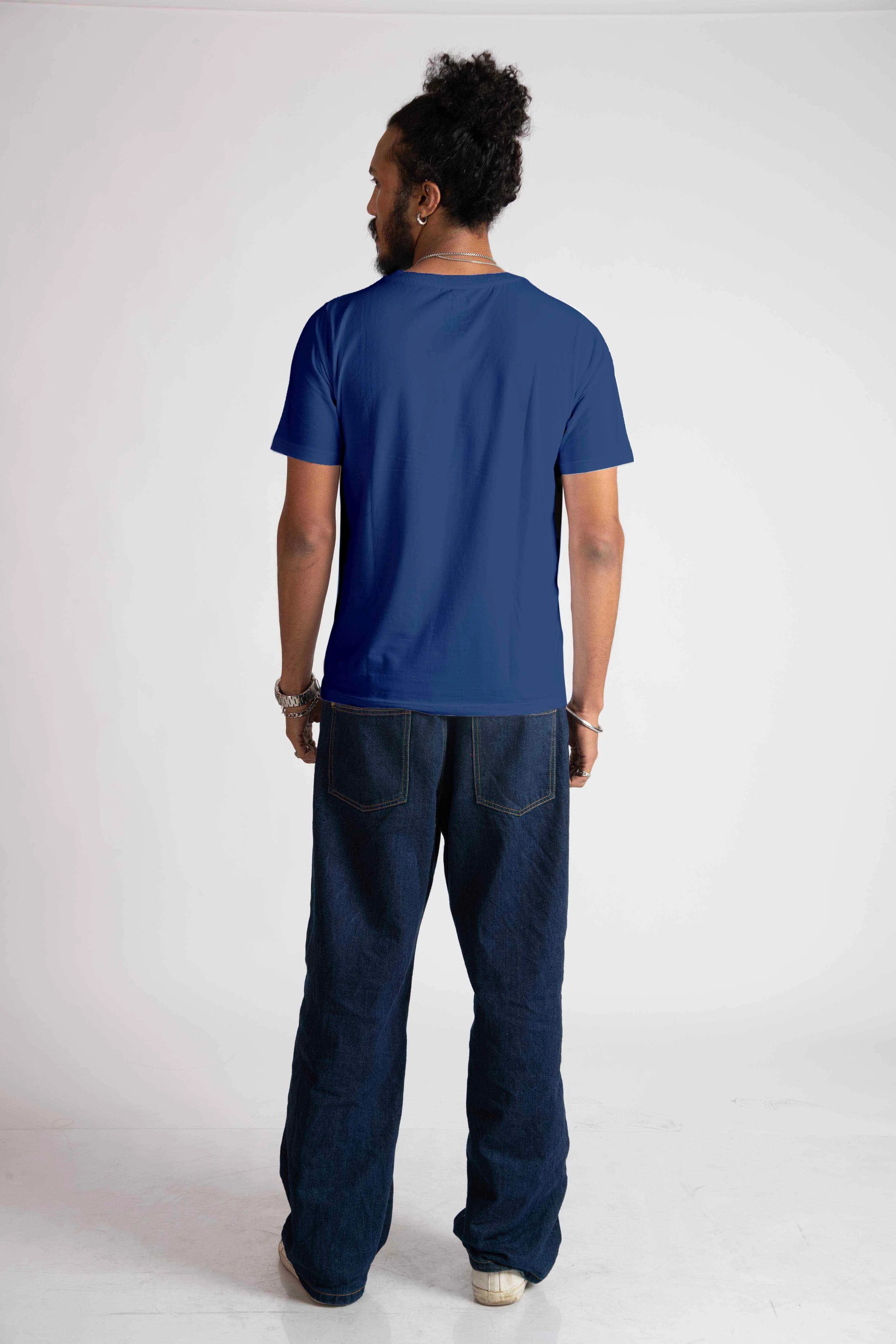 Back view of man wearing blue jacquard regular fit t-shirt paired with dark jeans