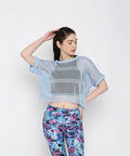 Blue netted top for women layered over a black sports bra, styled with colorful workout leggings