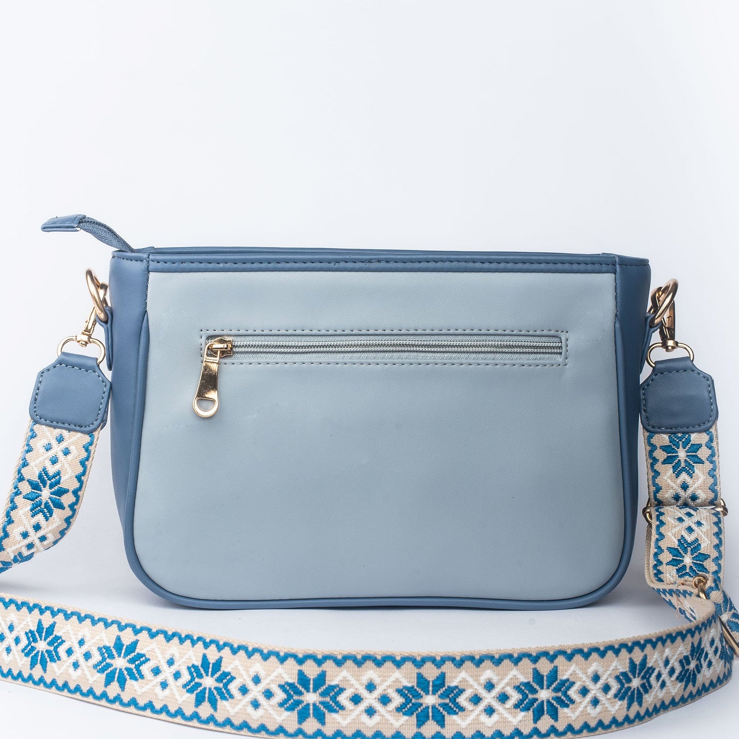 Stylish blue sling bag for women with an adjustable strap and zipper pocket on the back