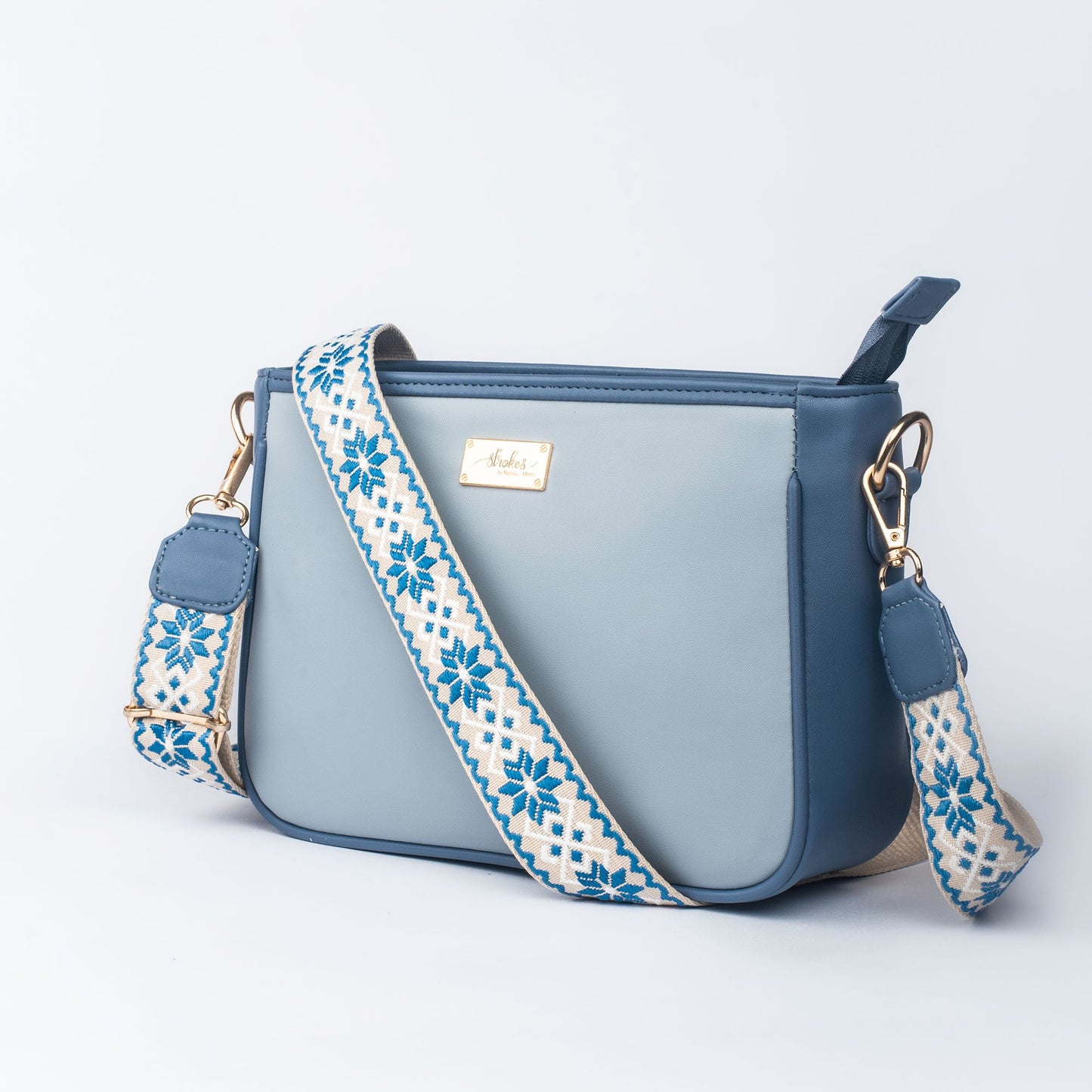 Stylish blue sling bag for women with a patterned strap, perfect for everyday use