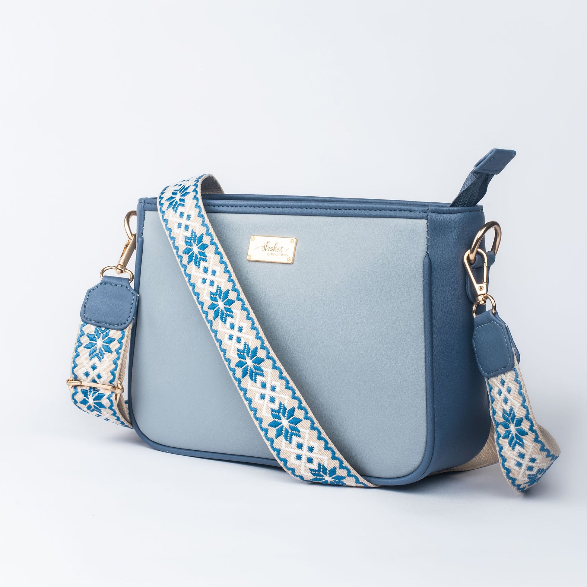 Stylish blue sling bag for women with a patterned strap, perfect for everyday use