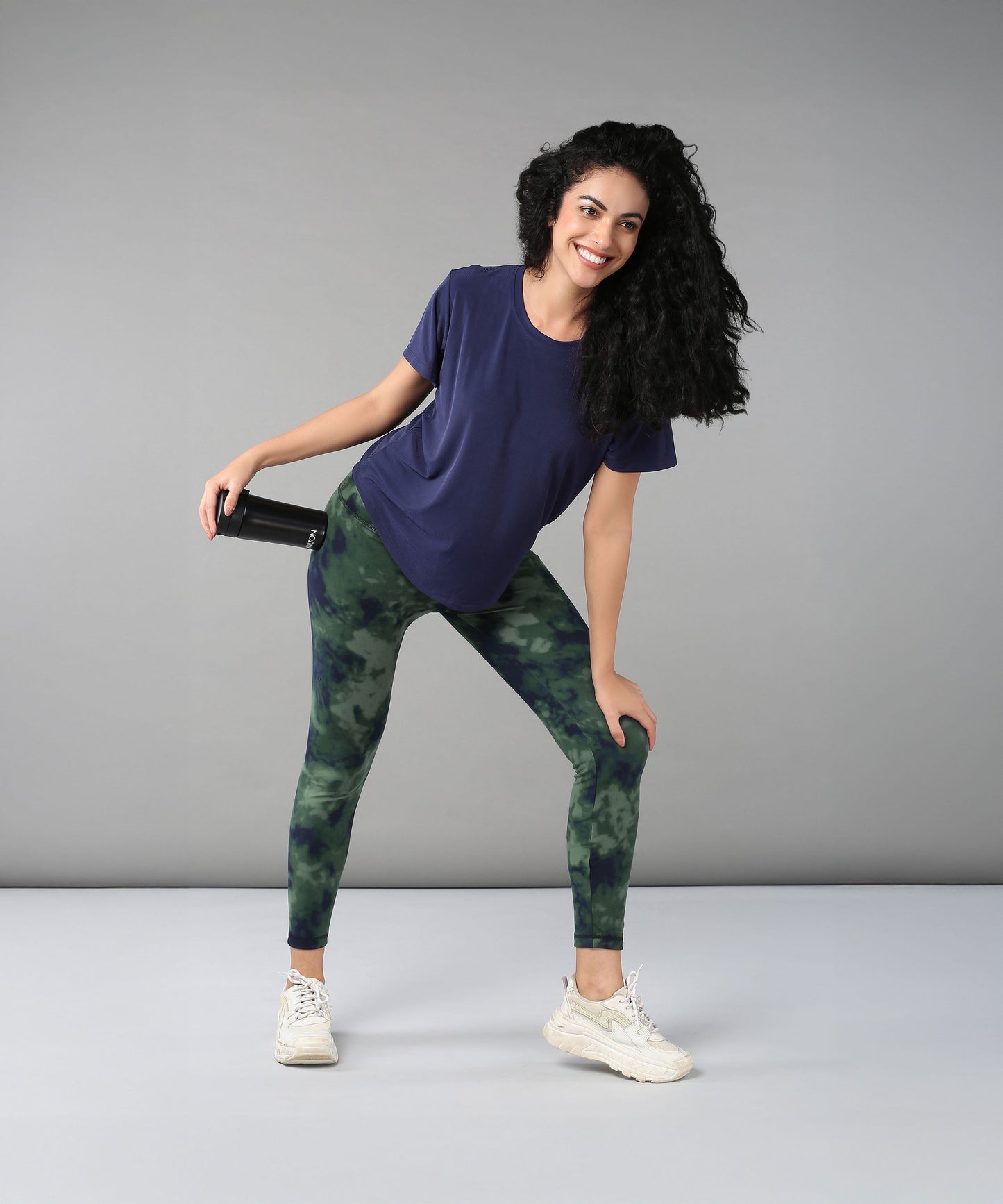 Active model wearing a blue soft t-shirt for women paired with stylish leggings and sneakers