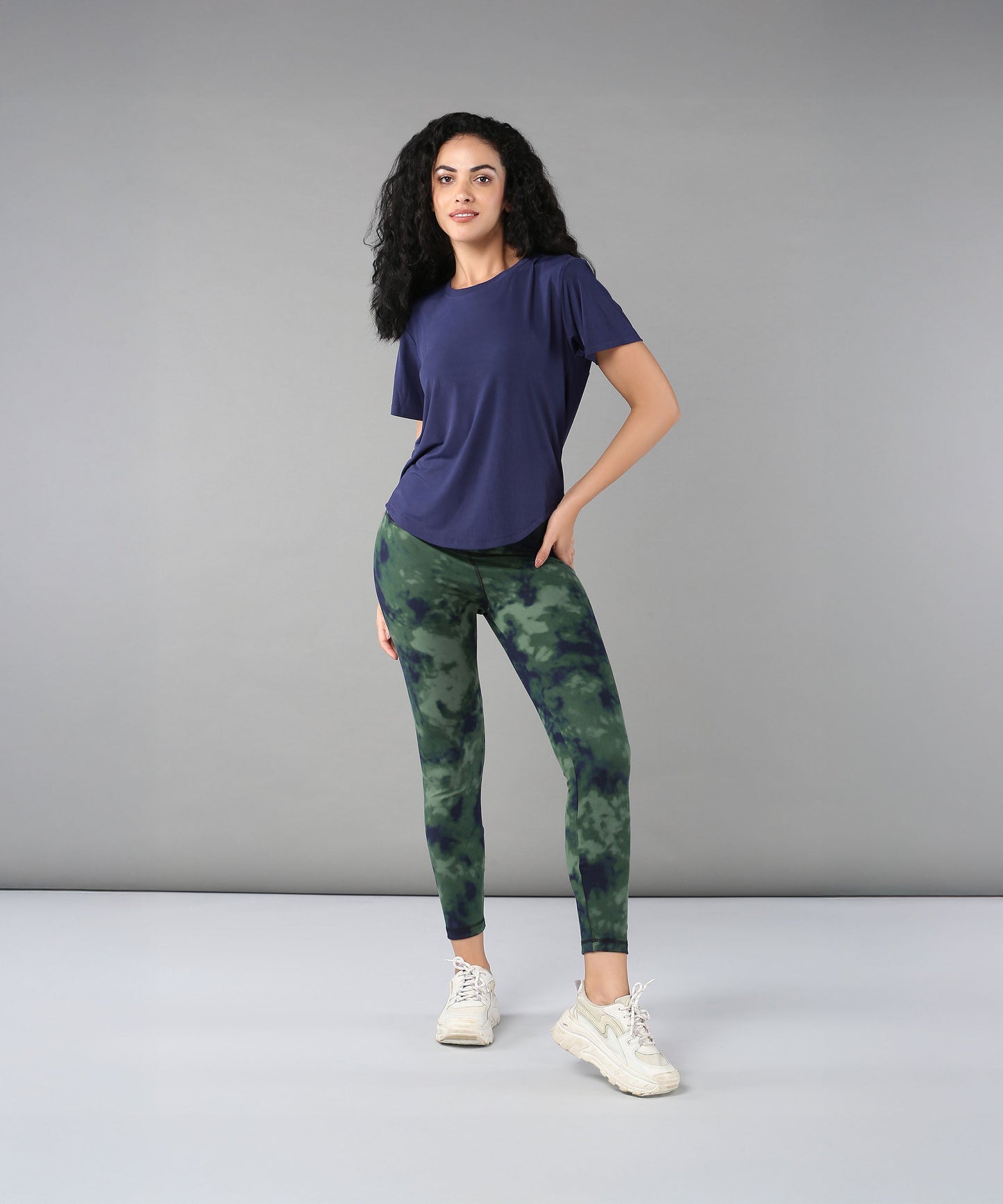Stylish model wearing a blue soft t-shirt for women paired with green camo leggings