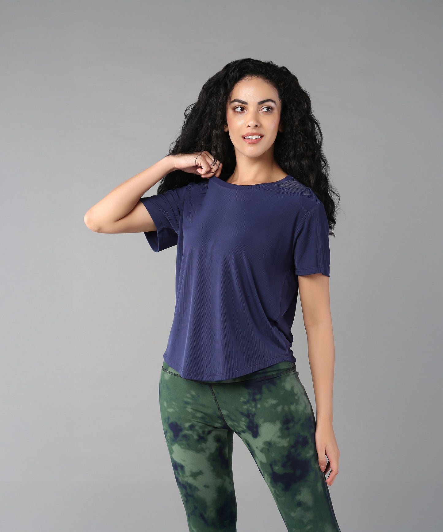 Model wearing a blue soft t-shirt for women paired with stylish green tie-dye leggings