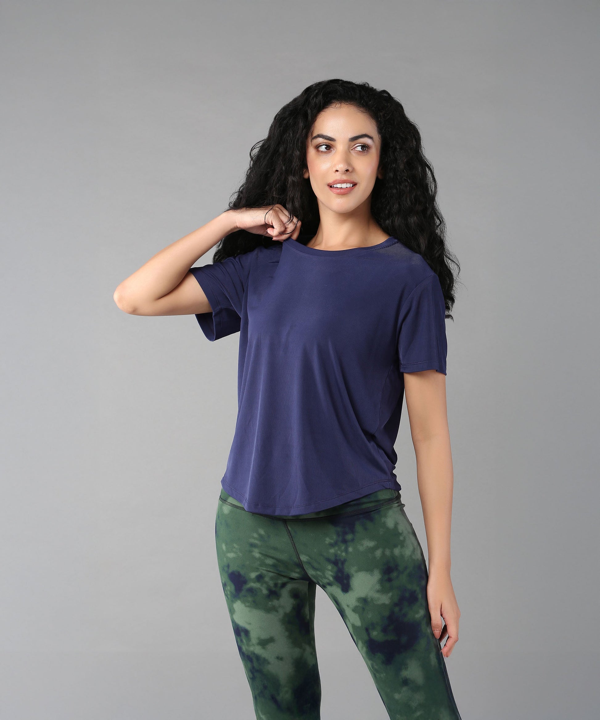 Model wearing a blue soft t-shirt for women paired with stylish green tie-dye leggings