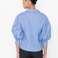 Stylera blue v-neck blouse with puff sleeves shown from the back on a female model