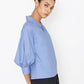 Stylera blue v-neck blouse with puffed sleeves paired with black pants