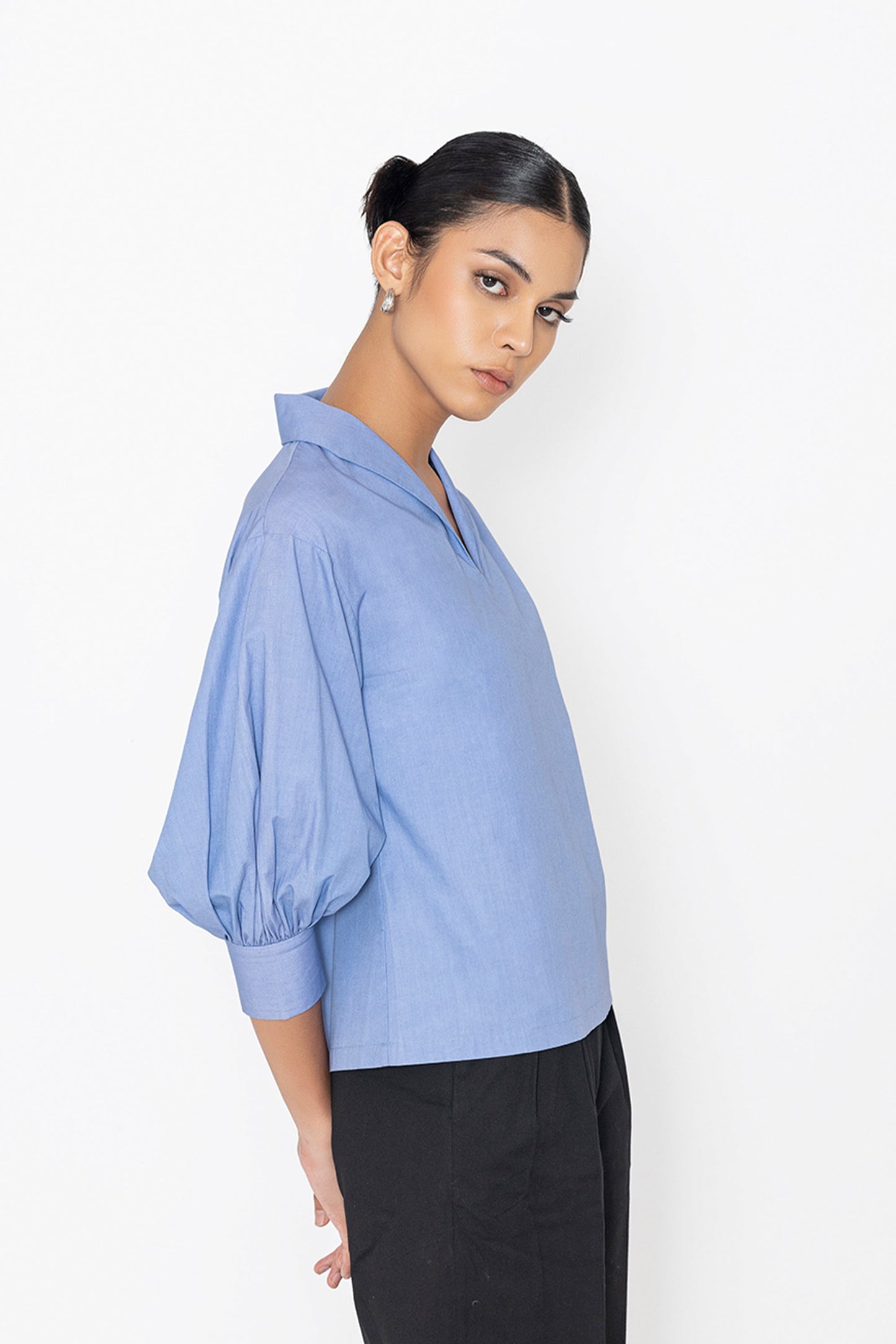 Stylera blue v-neck blouse with puffed sleeves paired with black pants