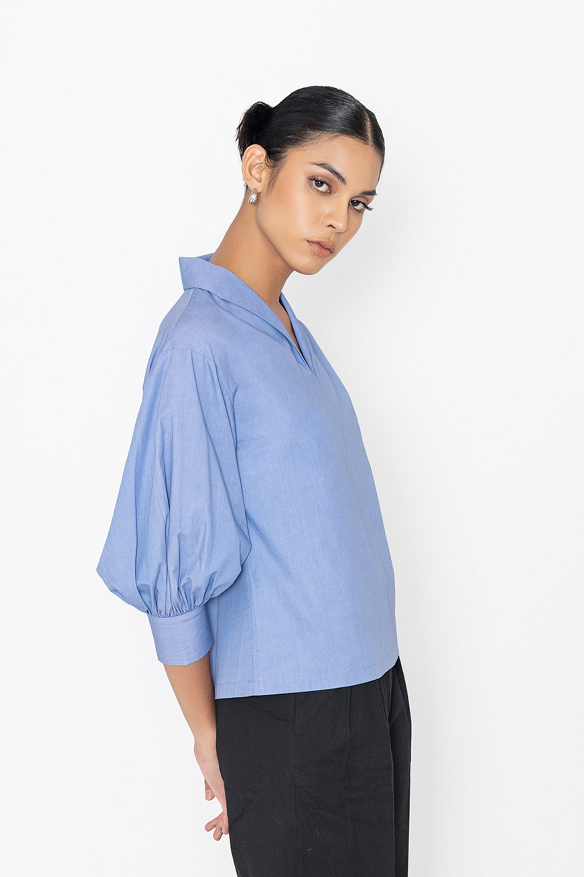Stylera blue v-neck blouse with puffed sleeves paired with black pants
