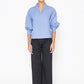 Stylera blue v-neck blouse with puff sleeves paired with black wide-leg pants