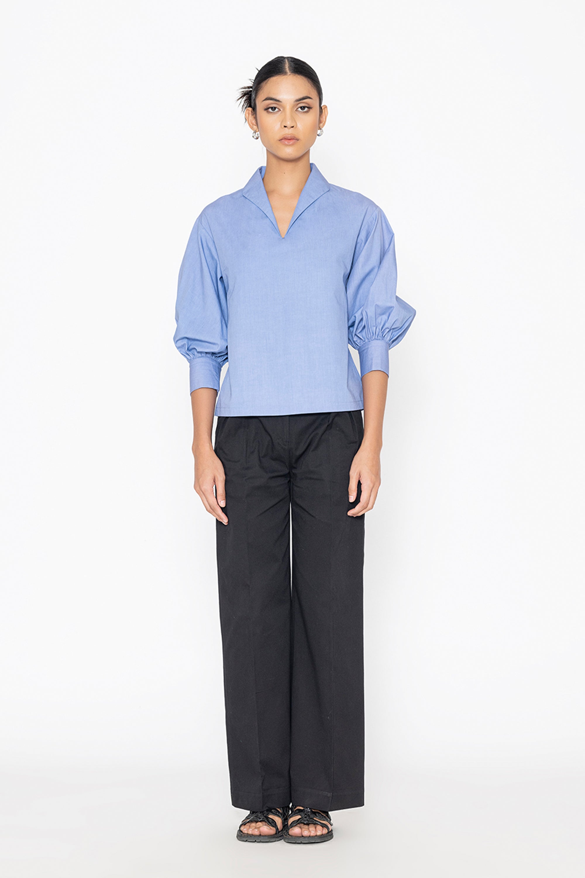 Stylera blue v-neck blouse with puff sleeves paired with black wide-leg pants