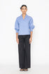 Stylera blue v-neck blouse with puff sleeves paired with black wide-leg pants
