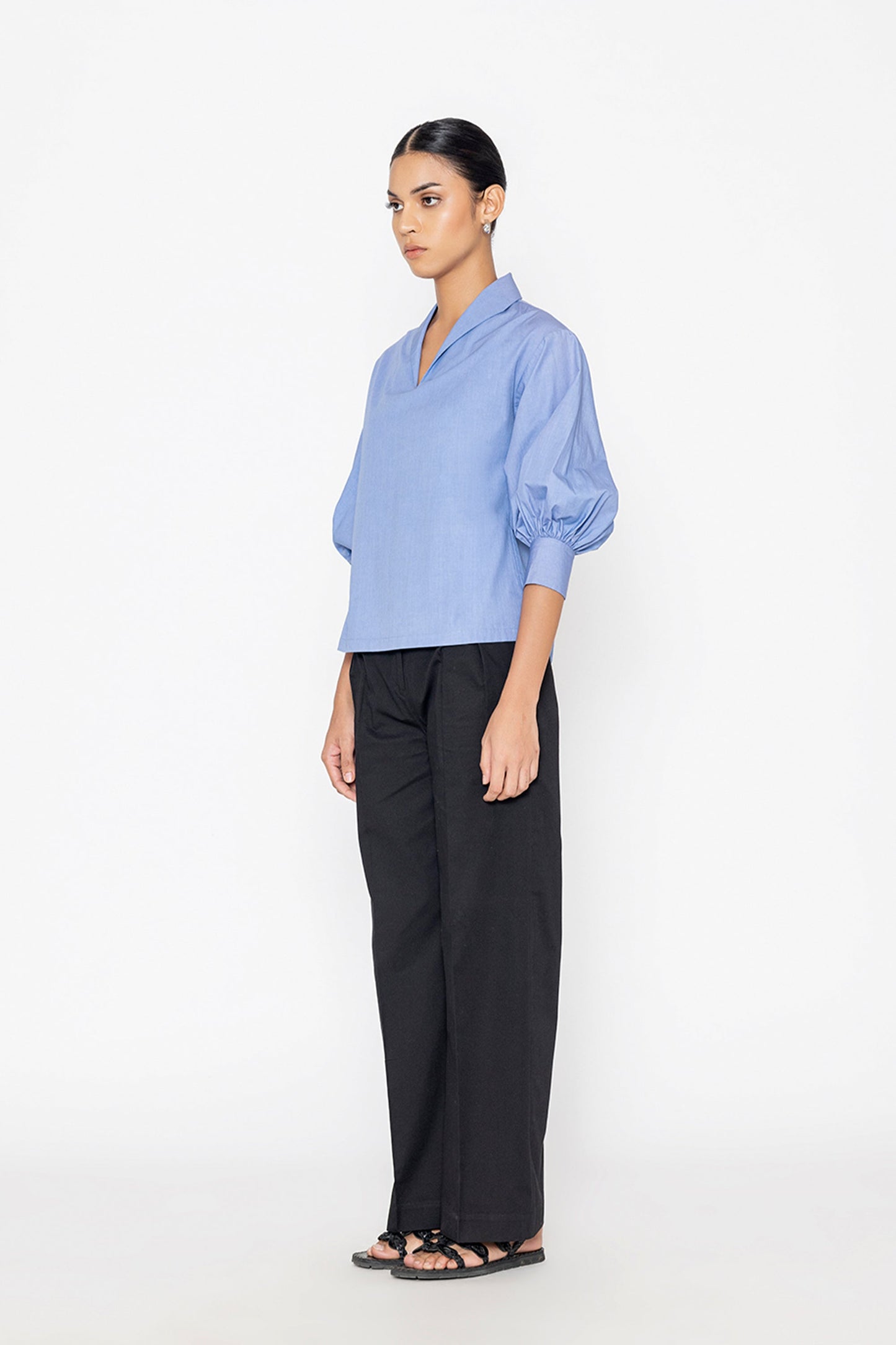 Stylera blue v-neck blouse with puffed sleeves paired with black wide-leg pants