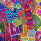Colorful handmade ethnic vest for women patchwork with embroidered flowers buttons and textured fabric close up