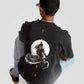 Stylera Lifestyle charcoal black oversized t-shirt with graphic design worn by seated man