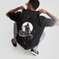 Stylera Lifestyle charcoal black oversized t-shirt with graphic moon and text design worn by a crouching model