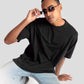 Model wearing Stylera Lifestyle charcoal black oversized t-shirt paired with light blue jeans and sunglasses