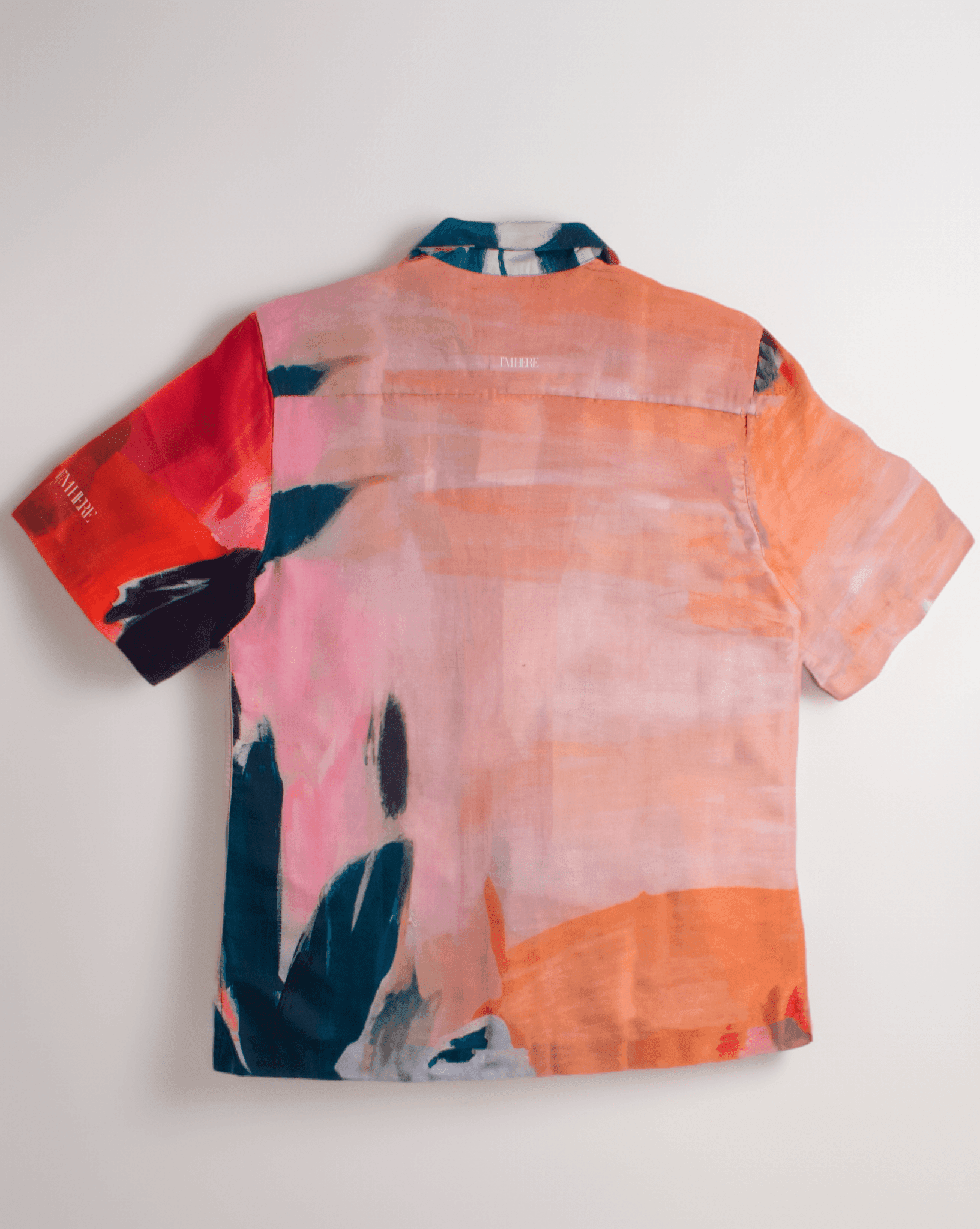 Back view of Stylera men's printed resort shirt in coral pink orange and navy abstract watercolor print