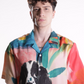 Stylera men's printed resort shirt on male model with colorful tropical print and large dog illustration