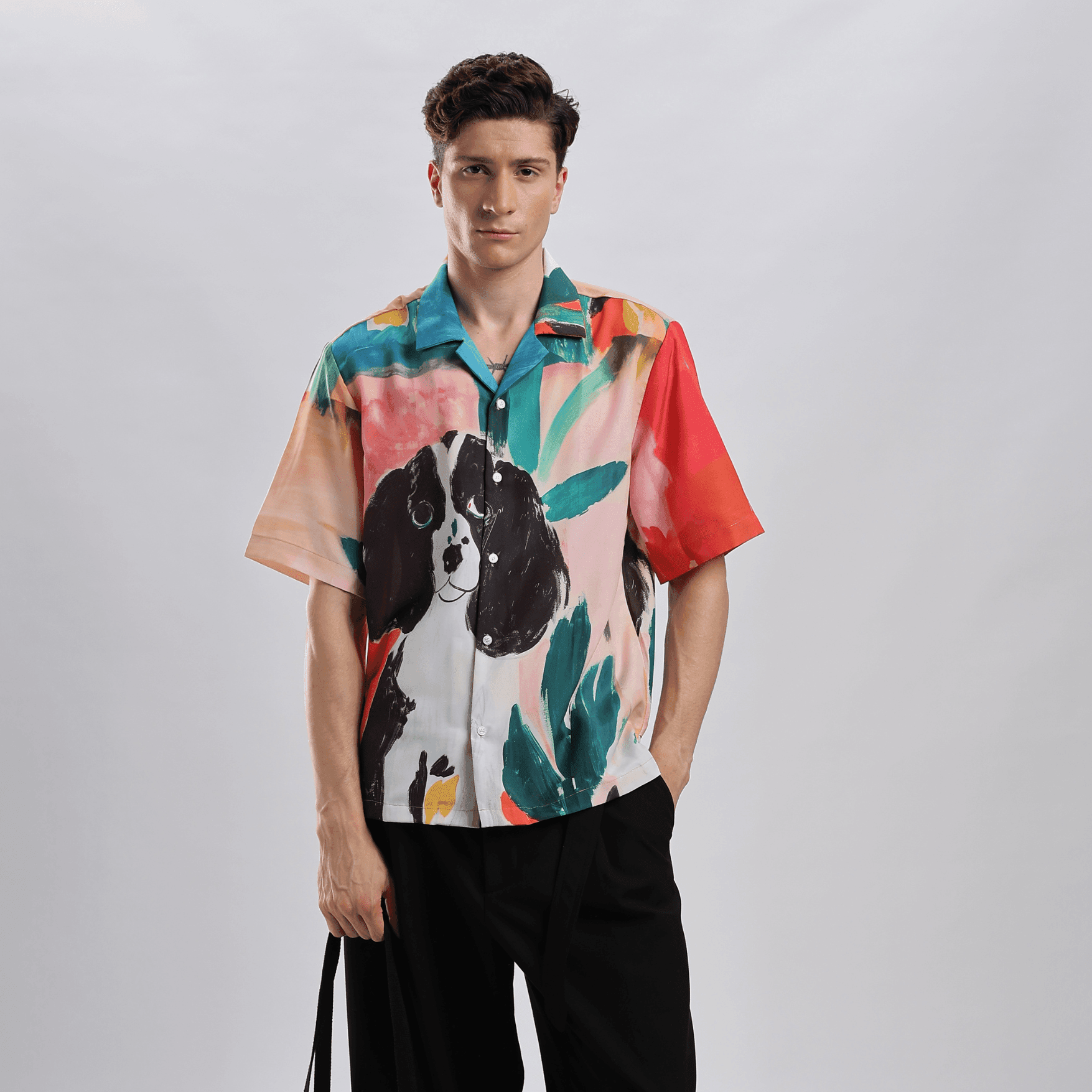 Model wearing Stylera men's printed resort shirt with colorful dog and tropical leaf watercolor print