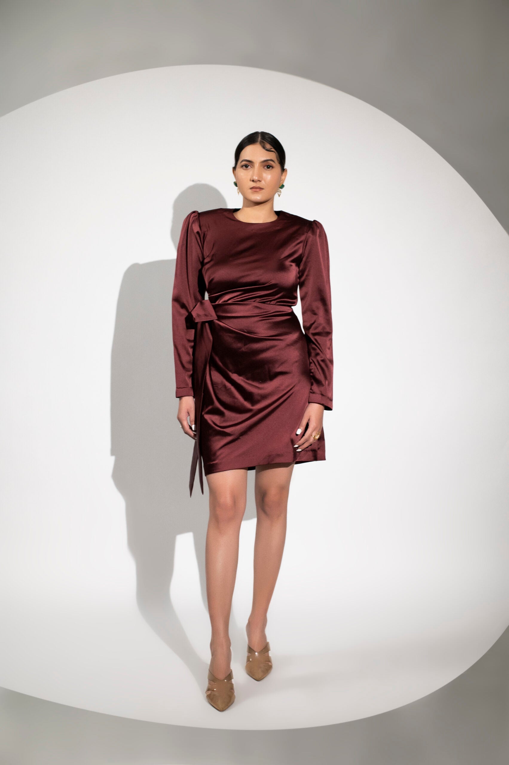 Burgundy satin party dress by Stylera with long sleeves and a stylish wrap design