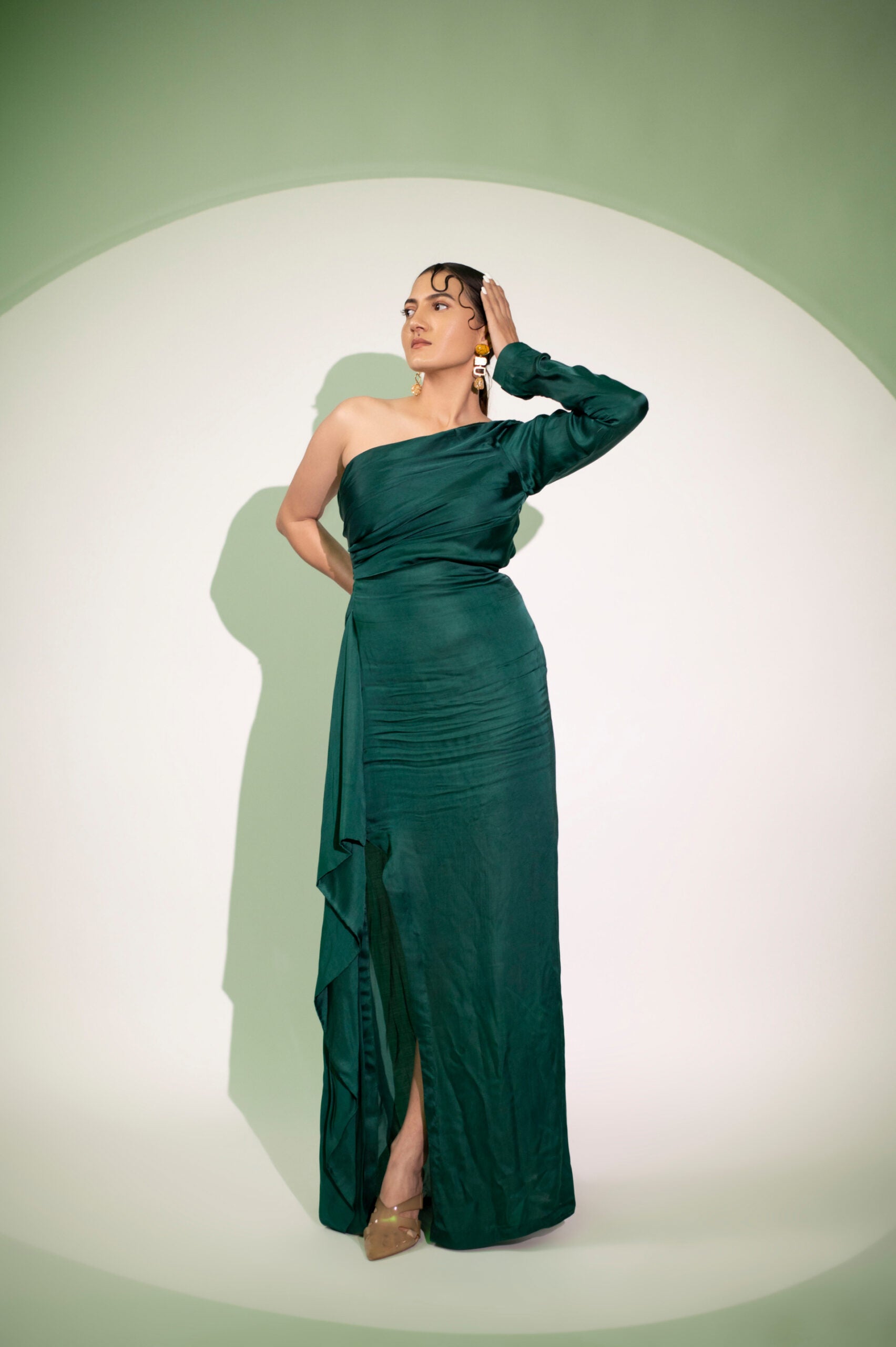 Elegant green designer single sleeve gown with a thigh-high slit for a stylish look, perfect for evening wear