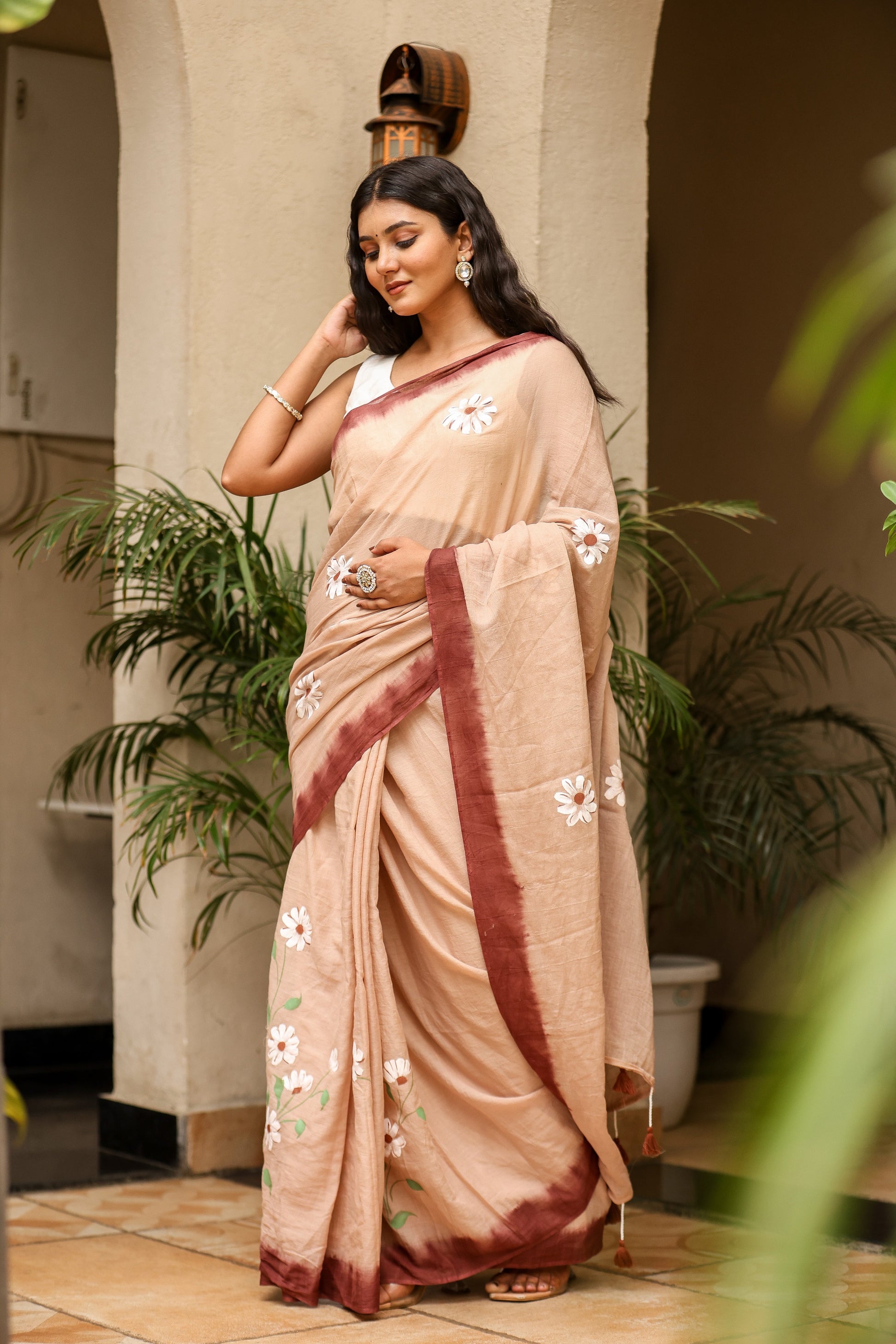 Stylera malmal saree with designer border in soft beige featuring floral embroidery, perfect for elegant occasions. Buy malmal saree with designer border.