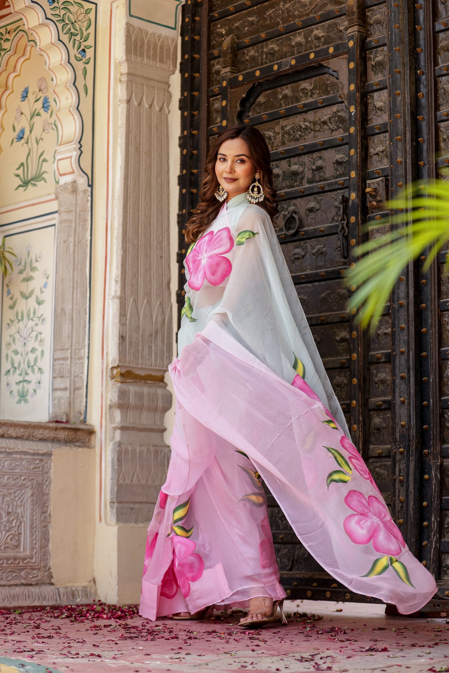 Model showcasing a buy trendy chiffon saree with pink floral patterns, perfect for festive occasions.