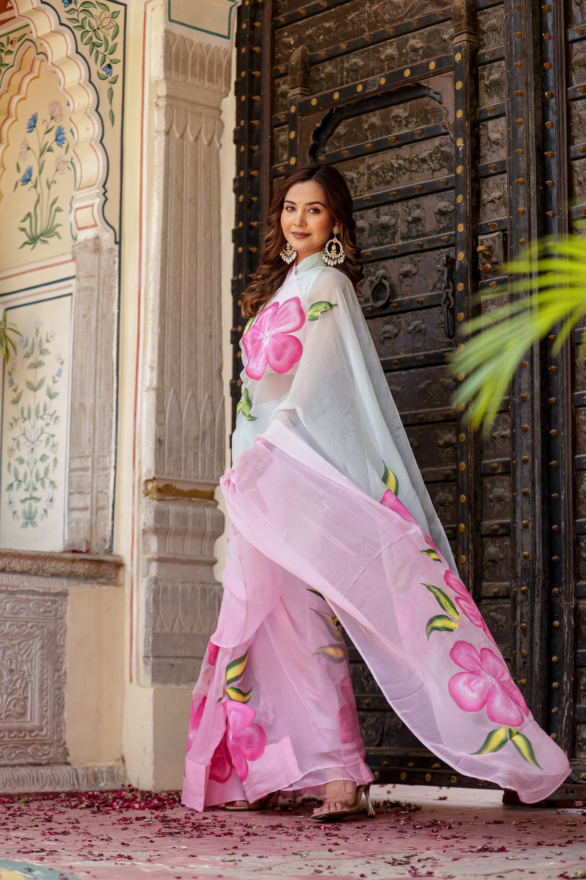 Model showcasing a buy trendy chiffon saree with pink floral patterns, perfect for festive occasions.