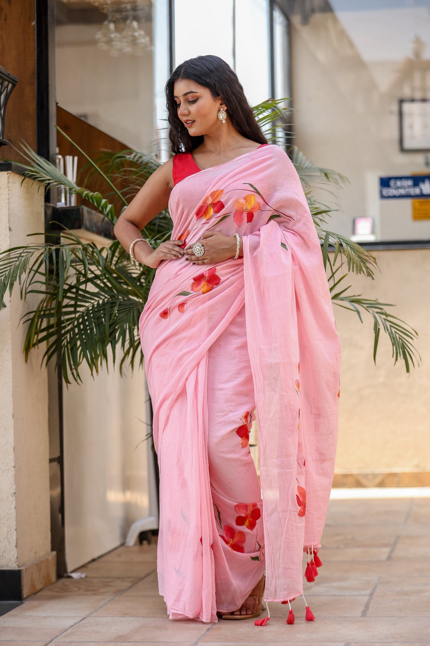 Elegant pink malmal saree with floral prints and tassels, perfect for modern occasions to buy trendy malmal saree.