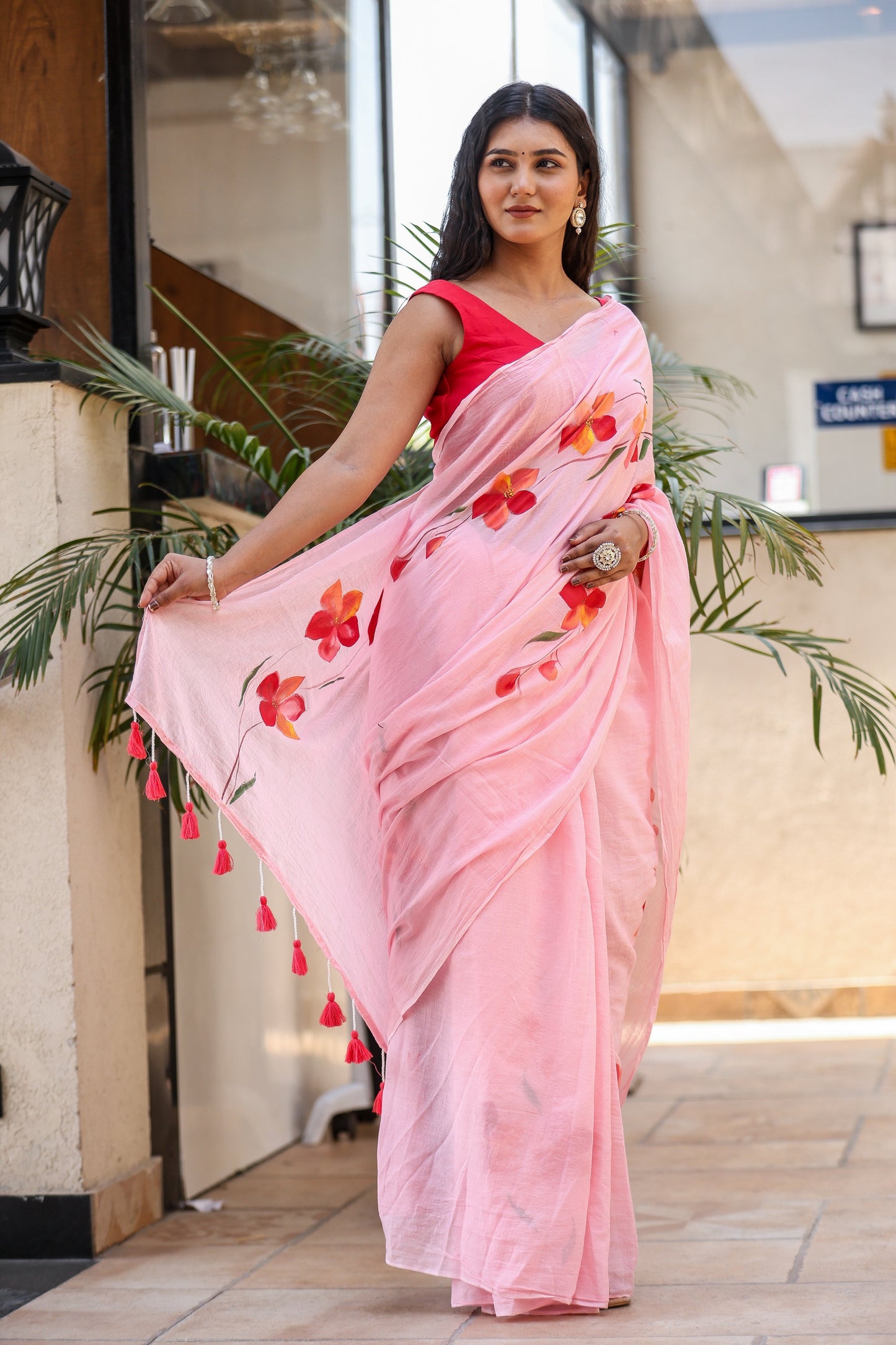 Elegant pink malmal saree with floral prints and tassels, perfect to buy trendy malmal saree.