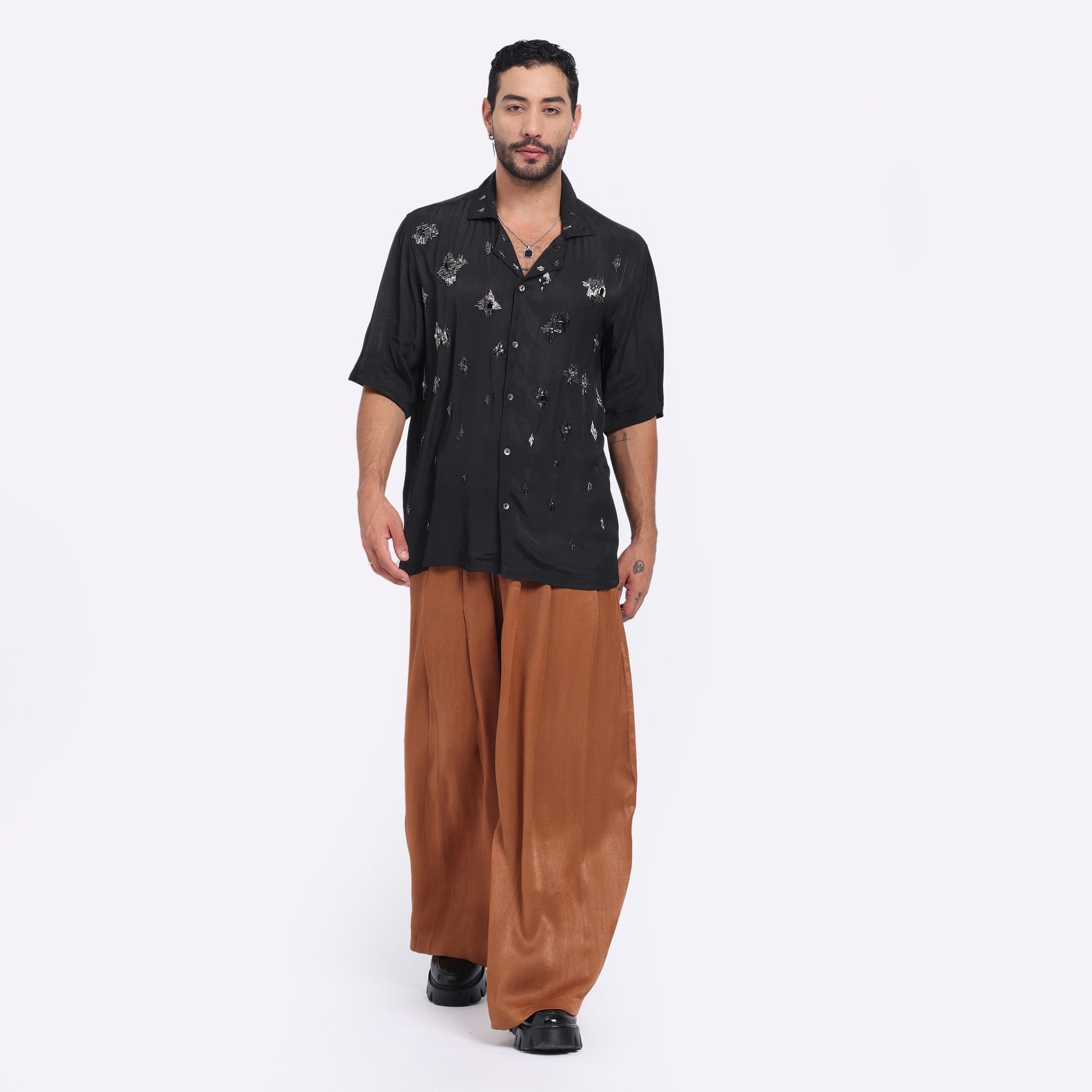 Man wearing caramel wide leg pants paired with a stylish black shirt for casual outings
