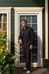 Man in casual black outfits for men standing by a door with stylish casual wear