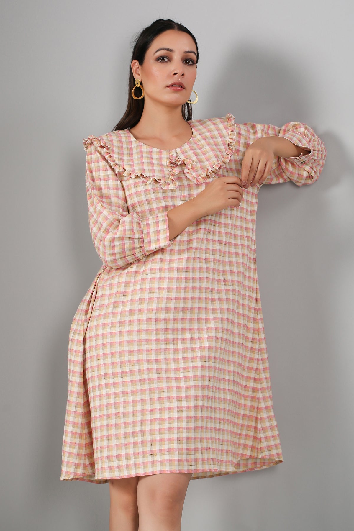 Women in a casual checkered dress for women featuring ruffled neckline and three-quarter sleeves