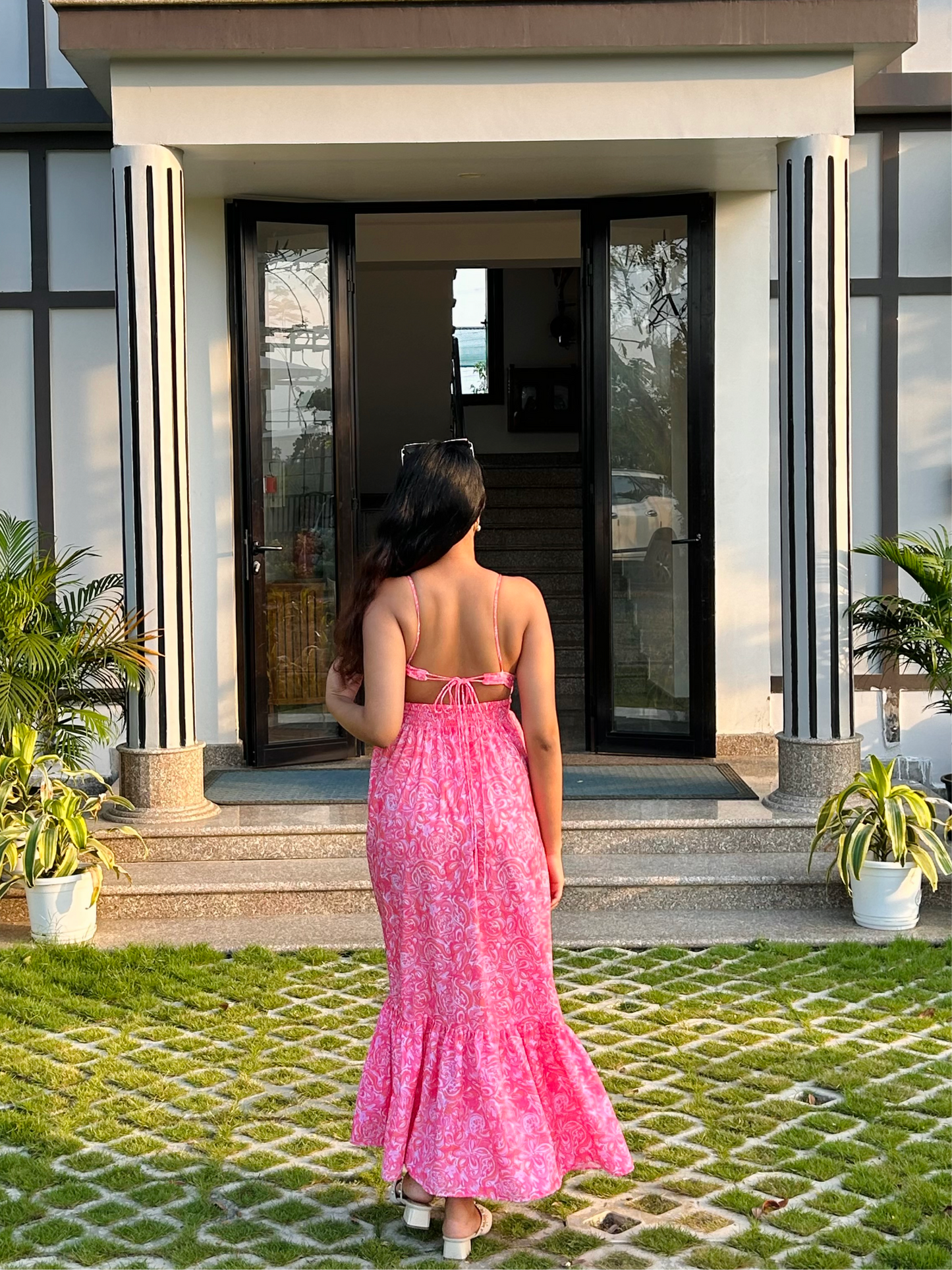 Stylera casual floral maxi dress back view on woman standing outside modern entryway