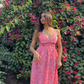 Model wearing Stylera pink paisley casual floral maxi dress with V neckline and ruffle hem in garden
