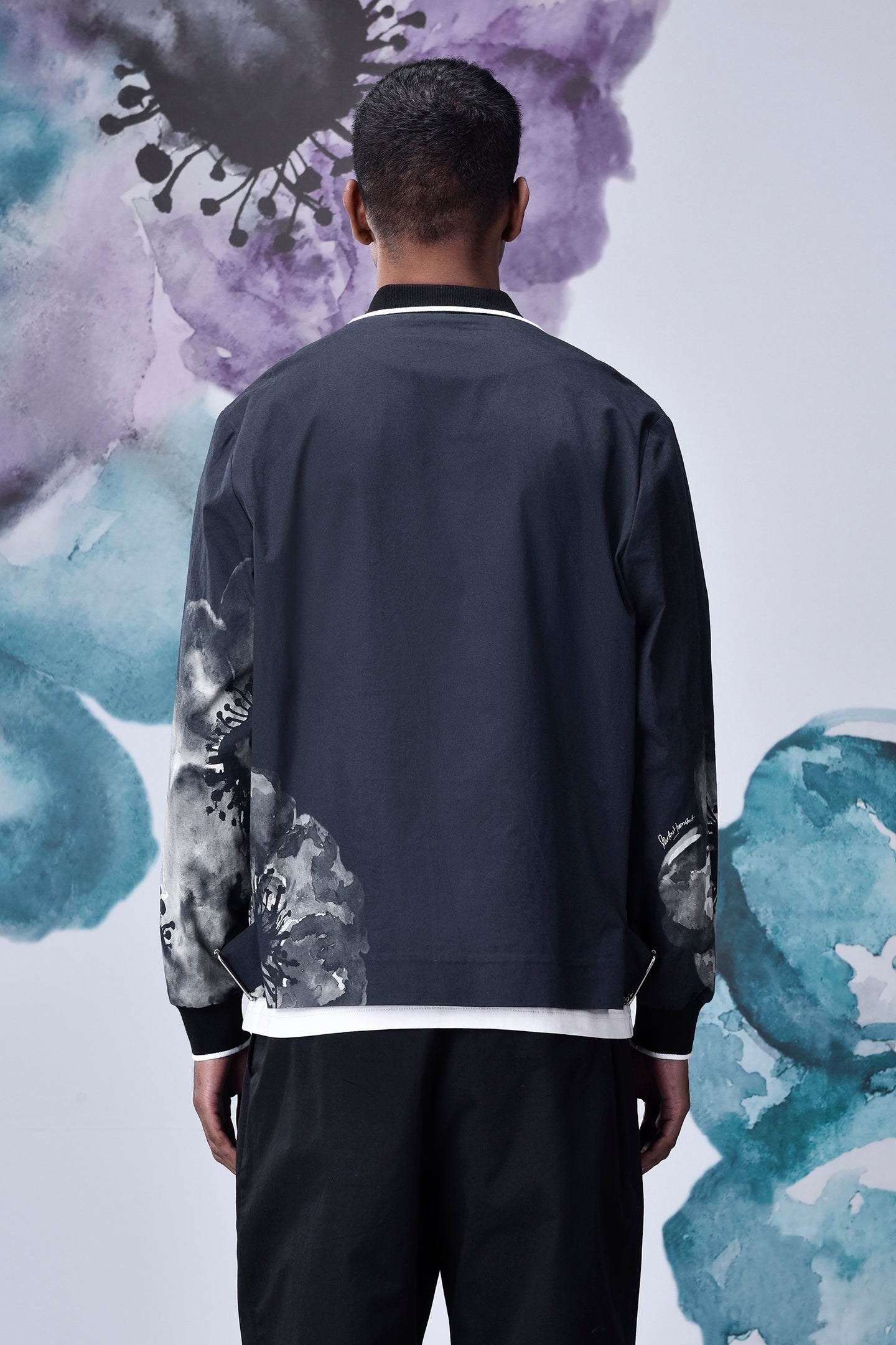 Back view of man wearing Stylera casual flower patterned zip jacket in dark navy with white trim