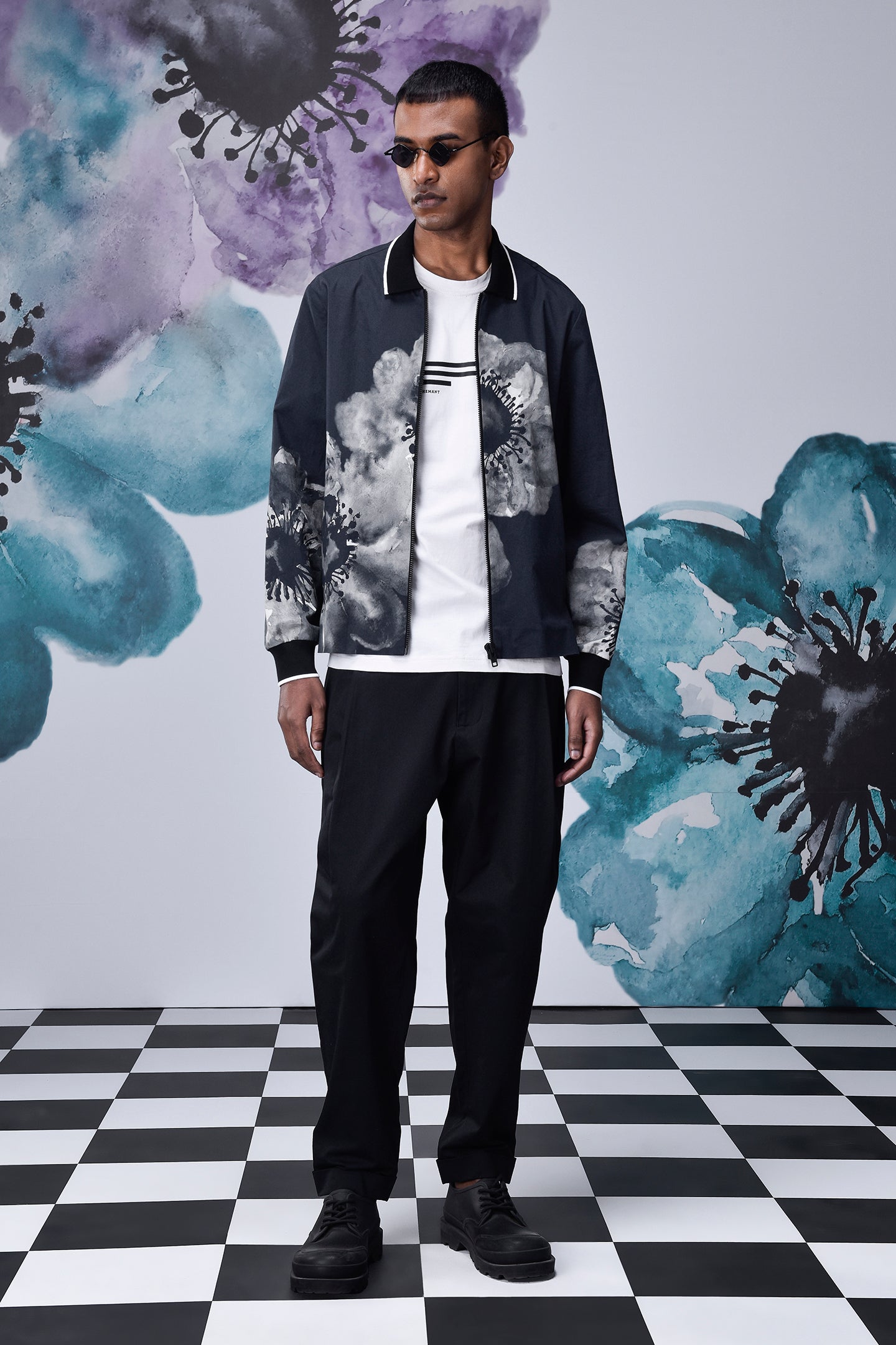 Stylera model wearing casual flower patterned zip jacket in navy with black pants