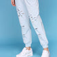 Light blue casual off shoulder lounge set with stylish distressed joggers for a relaxed look
