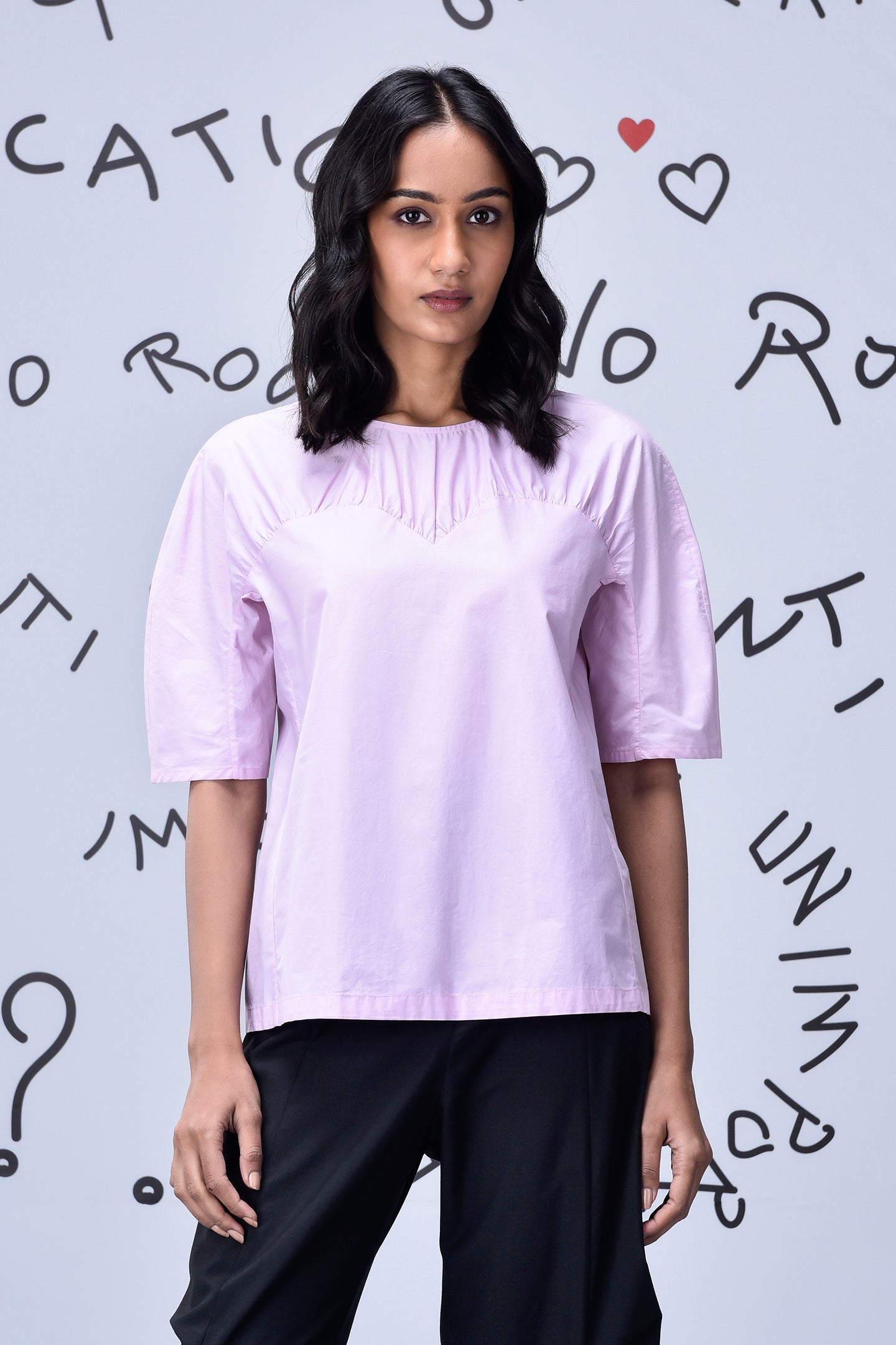 Stylera casual pink top for women on model with gathered neckline elbow sleeves relaxed fit black pants