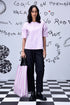 Stylera casual pink top for women worn with black trousers and striped tote on checkered floor