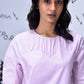 Stylera casual pink top for women with round neckline gathered yoke and elbow sleeves on model