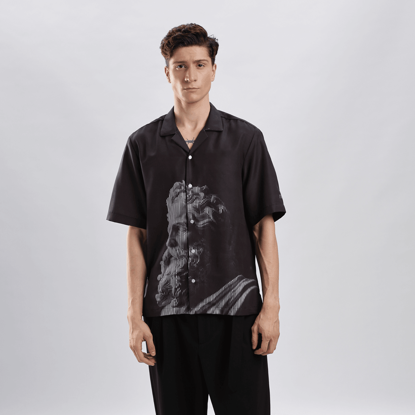 Stylera black short sleeve button shirt with classical statue graphic worn by model casual statement shirts for men